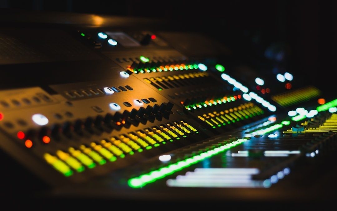 Ljudmixer med upplysta equalizerskjutreglage i mörk studio