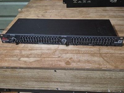 Svart grafisk equalizer med många skjutreglage på ett träbord